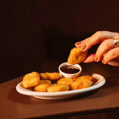 Porção de nuggets dourados com molho barbecue