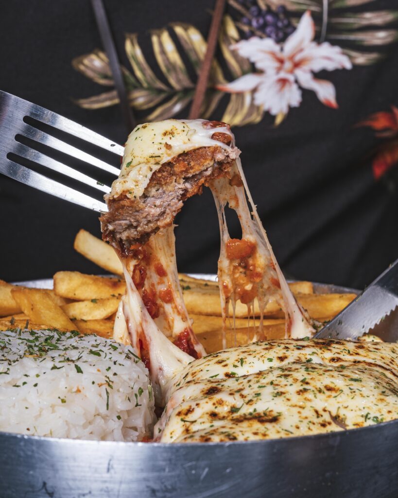 Delicioso prato com arroz, batata frita, azeite, parmegiana suculenta com muito molho e queijo.